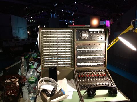 Old telephone switchboard with patch panels, rotary dial and handset on a desk